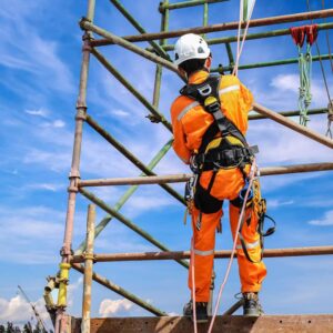 lavoratore edile che indossa cinture di sicurezza durante l'allestimento e lavoro su ponteggi