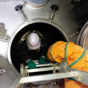 Operaio entra nella vasca dotata di sistema di ventilazione durante il lavoro