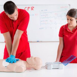 Operatori sanitari che fanno prove di massaggio cardiaco su manichino